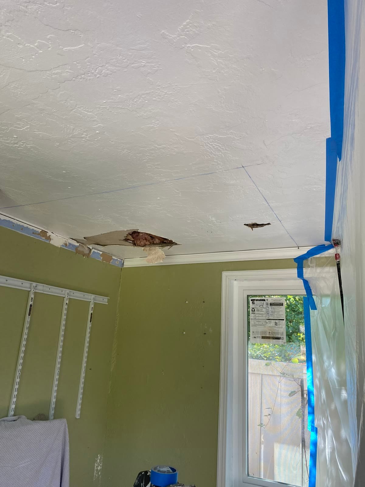 Before: damaged ceiling corner with torn paper