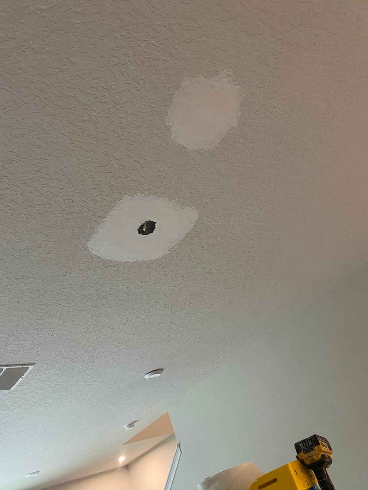 Before: two mudded ceiling patches, texture not yet matched